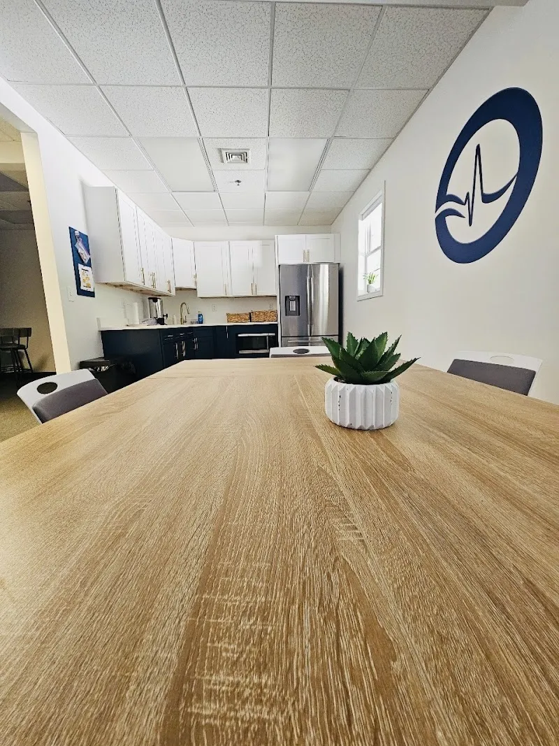 Bright communal dining area with a wooden table at New Wave Recovery Center Massachusetts detox center in Boston.