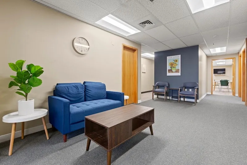 Inviting waiting area with blue couch at Chapters Recovery Center Inc, a treatment center in Boston.