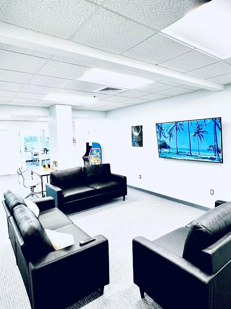 Bright lounge area with black sofas at Northstar Recovery Center, a treatment center in Boston.